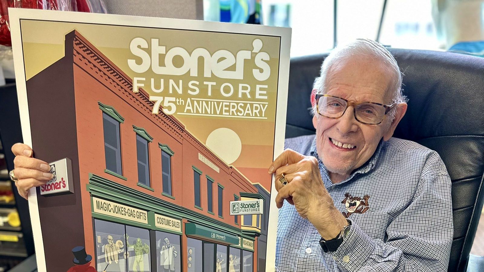 Dick Stoner holds the official poster by Phan Gear Prints for the Stoner’s Funstore 75th anniversary block party. The store began with his Dick Stoner’s father, Albert Stoner, in 1949.