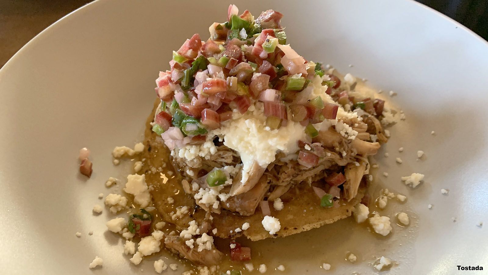 The tostada with braised chicken, chipotle, rhubarb pico, cotija cheese, and crème fraîche delivers a balance of flavors and textures.