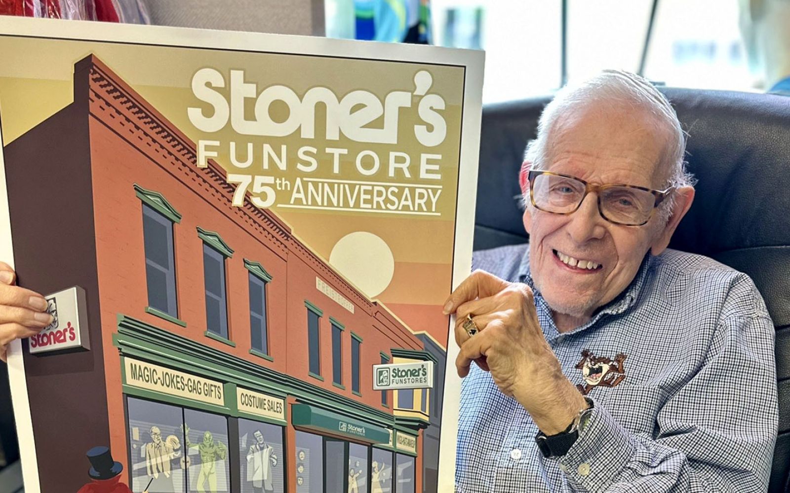 Dick Stoner holds the official poster by Phan Gear Prints for the Stoner’s Funstore 75th anniversary block party. The store began with his Dick Stoner’s father, Albert Stoner, in 1949.